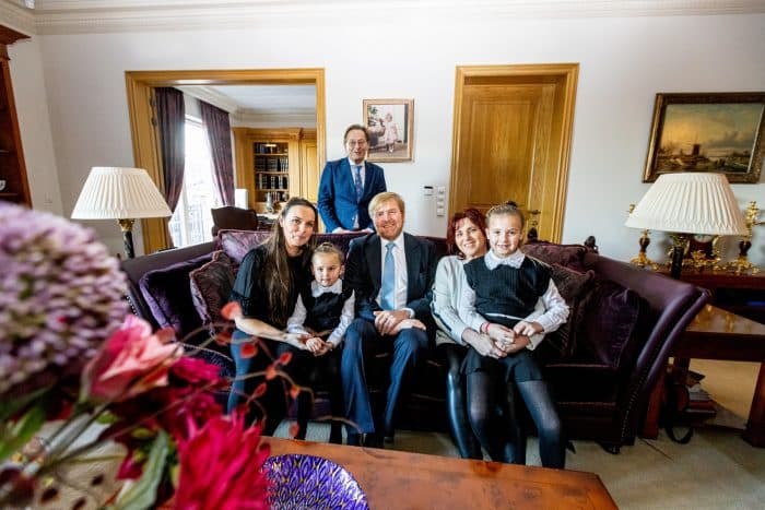 De koning op de foto met een familie uit het woonwagencentrum, tijdens de bezichtiging van hun woning.