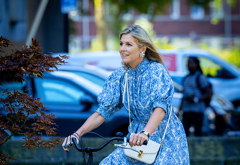 Máxima fietst in vrolijke zomerjurk door Amsterdam Zuid-Oost